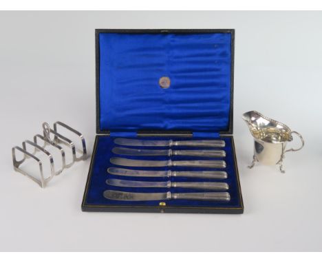 A George V Silver Four Slot Toast Rack (Birmingham 1929, W.D), silver creamer (Birmingham 1929, C&amp;S Ltd.) and cased set o