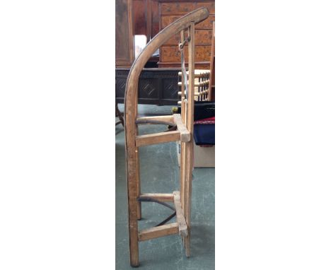 A vintage wooden toboggan with metal rails