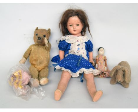 An early child's doll with closing blue eyes in blue dress, together with an early peg doll in floral dress, a baby and wool 