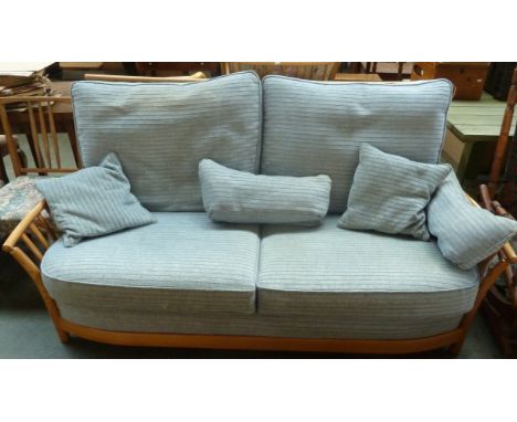 A pine Ercol two-seater sofa with removable pale blue cushions