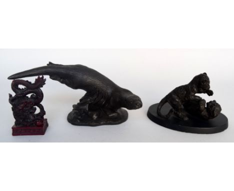 A resin figure of an otter diving with a resin statue of two lion cubs playing together with a resin figure of a chinese drag