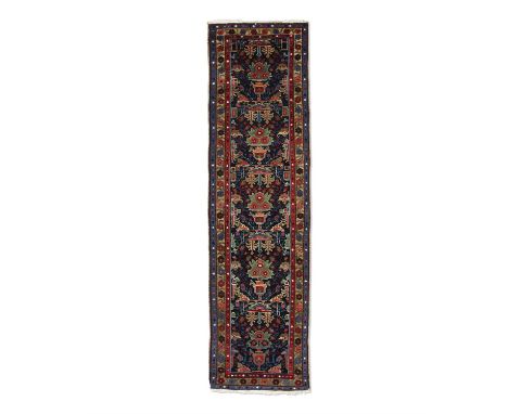 AN ANTIQUE KARADJA RUNNER, hand knotted in the village district of Karadja and Heriz, NW Persia, c.1890-1910, with a series o