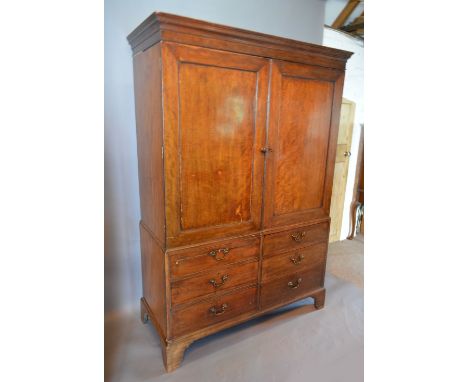 A Regency Mahogany Press Cupboard, the moulded cornice above two panelled doors enclosing hanging space and further drawers, 