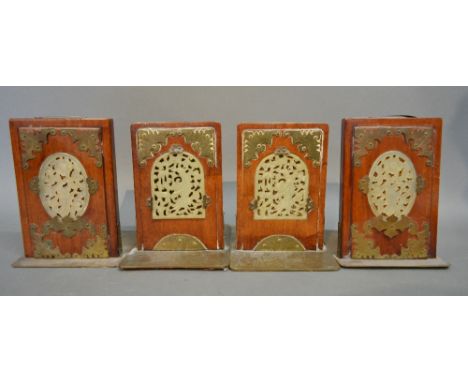 A Set of Four Chinese Hardwood and Brass Mounted Plaques, each set with a pierced jade panel, 16 x 10 cms