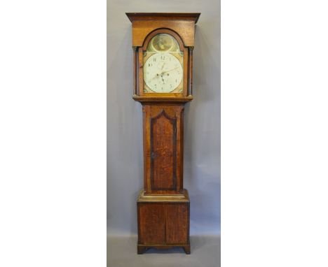 A George III Oak Long Case Clock, the rectangular arched hood with turned pilasters by the shaped door raised upon bracket fe