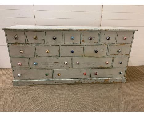 A Painted pine set of apothecary style drawers with ceramic multi coloured handles. 