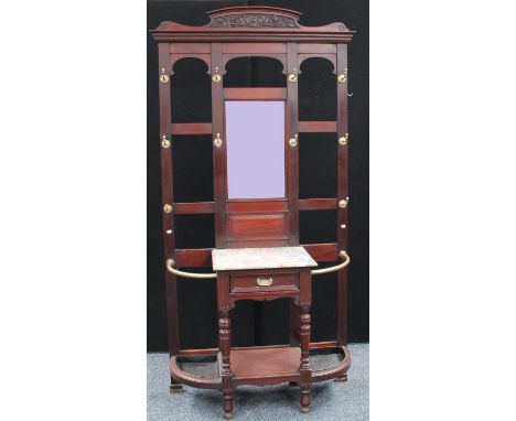 A late 19th/early 20th century mahogany hall stand, outswept cornice above a bevelled rectangular mirror plate and an arrange
