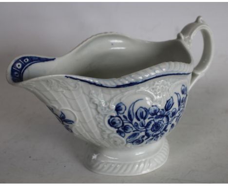 A Worcester blue and white sauce boat, crisply moulded with overlapping scales painted with flowers in three panels, the inte