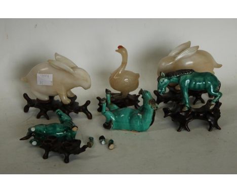 A Chinese soapstone carving of a rabbit, hardwood stand, 9cm high; another; a goose, similar; a set of three models of horses
