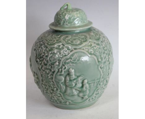 A Chinse celadon ovoid wine jar and cover, moulded in relief with four reserves of traditional figures below a ruyi frieze, d