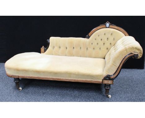 A Victorian ebonised and parcel-gilt chaise longue/day bed, arched cresting rail centred by a Jasperware type plaque depictin