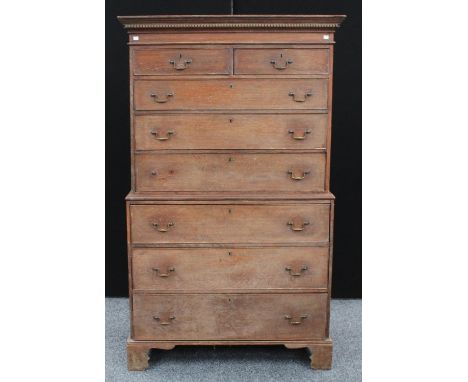A George III oak chest on chest, outswept cornice above two short and three long graduated drawers, the projecting base with 