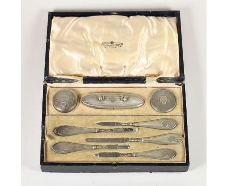 A silver manicure set, Birmingham 1925/6, with engine turned decoration, lacking scissors and two other pieces, cased 
