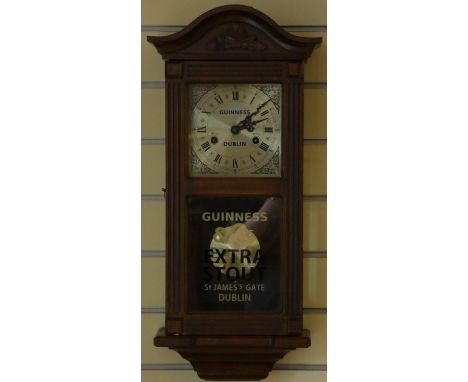 A mahogany cased manual wind wall clock, bearing 'Guinness Dublin' advertising to the dial. 