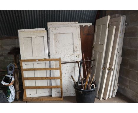 A quantity of white painted doors of varying sizes together with a wooden garden gate 