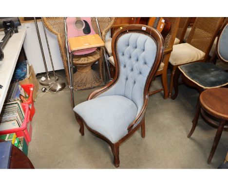 A blue upholstered button back bedroom chair 