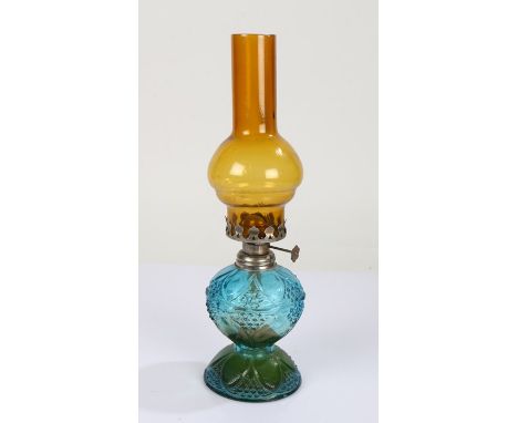 Small coloured glass oil lamp, with amber glass chimney above a blue and green glass reservoir, 33.5cm high