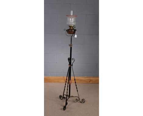 Early 20th Century Art Nouveau wrought iron oil standard lamp, having frosted glass shade with stylised flowers, above a copp