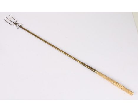 Victorian toasting fork, with a carved ivory handle above the brass stem and iron fork, 77cm long