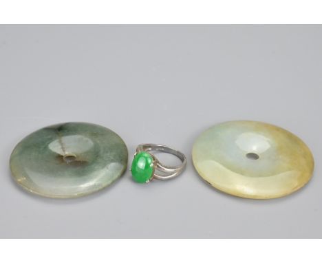 A Chinese white metal and green stone cabochon ring, size O (illegible stamp to ring interior). Together with two jade stone 