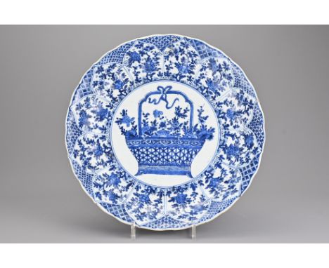 A large Chinese early 18th century blue and white porcelain dish decorated with basket of flowers. The deep dish with fluted 