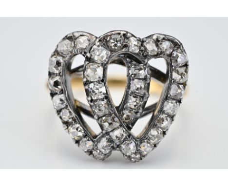 An antique ring with diamonds set in white metal double heart setting fixed to yellow metal diamond shaped band. Unmarked. Ri