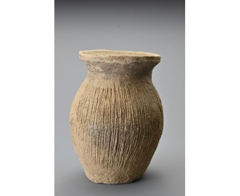 A Chinese Neolithic pottery jar. With oval shaped body with everted rim decorated with vertical cord impressed lines around t