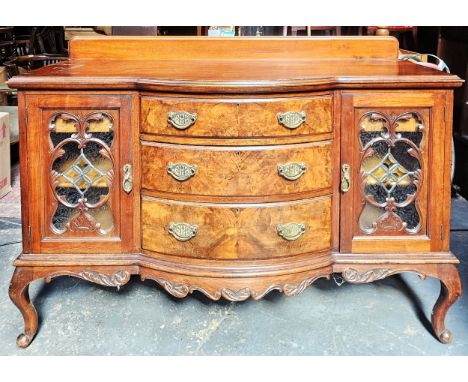 Victorian mahogany bow fronted three drawer sideboard., with carved glazed cupboard doors, on cabriole supports. Approx. 107 