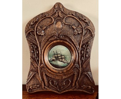 CARVED WOODEN FRAME SURROUNDING A MINIATURE CIRCULAR OIL ON PANEL, SHIP IN FULL SAIL ON STORMY SEAS, DIAMETER APPROX 8cm