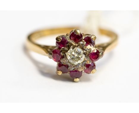 A ruby and diamond flower head cluster ring, set to the centre with an old cut diamond with a surround of round cut rubies,9c