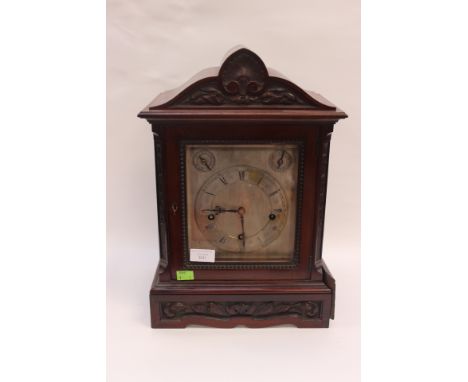 A late Victorian mahogany mantle clock, silvered face and Roman numerals
