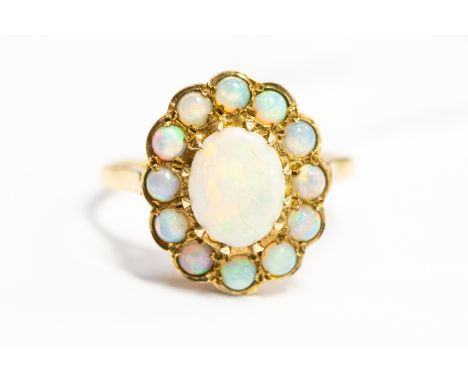 An opal and 9ct gold cluster ring, the central oval opal weight approx 1.50 carats with a border of twelve round opals, size 