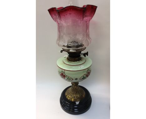 A Victorian brass mounted painted Vaseline glass oil lamp, with etched shade 