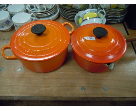 Two orange enamel Le Creuset lidded cooking pans