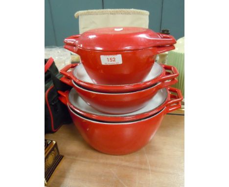 A set of graduated cast and enamel Creuset style casserole pans in red
