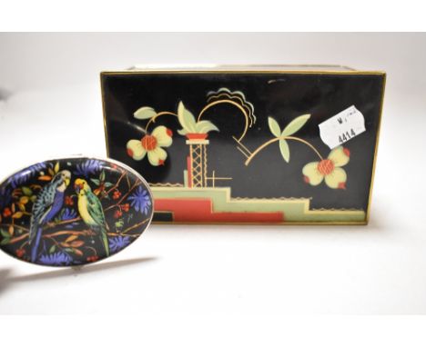 An Art Deco styled cigarette box having floral and geometric pattern painted to lid in red and green with gilt detailing, als