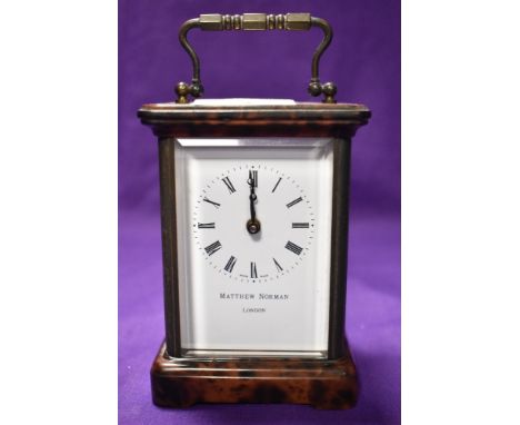 A 20th century carriage clock having bevelled glass gallery, visible movement and tortoise shell effect enamel to base and to