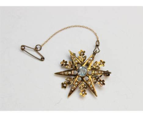 An Edwardian style 'aquamarine' and seed pearl set star form brooch, designed as a central untested aquamarine within a radia