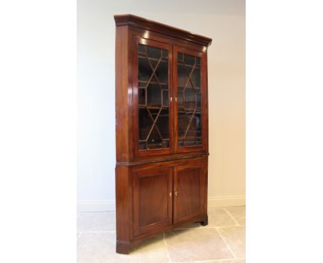 A 19th century mahogany freestanding corner cabinet, the moulded cornice above a pair of astragal glazed doors enclosing thre