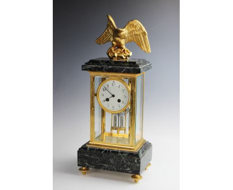 A late 19th century, French Empire style four glass clock, surmounted with gilt metal eagle with outstretched wings, above a 