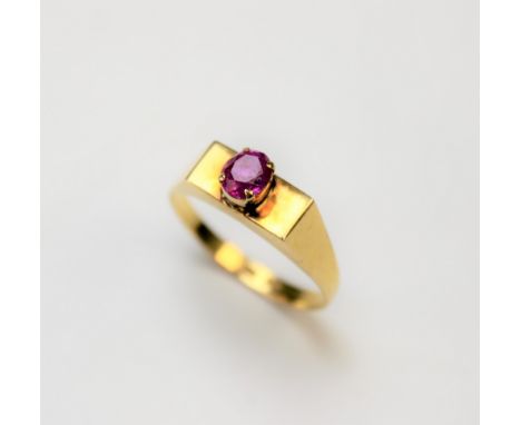 A ruby set ring, the central untested oval ruby within four claw setting and all set in yellow metal, stamped ?18k?, weight 2