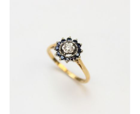 A diamond and sapphire cluster ring, the central brilliant cut diamond within a petal shaped setting, within a halo border su