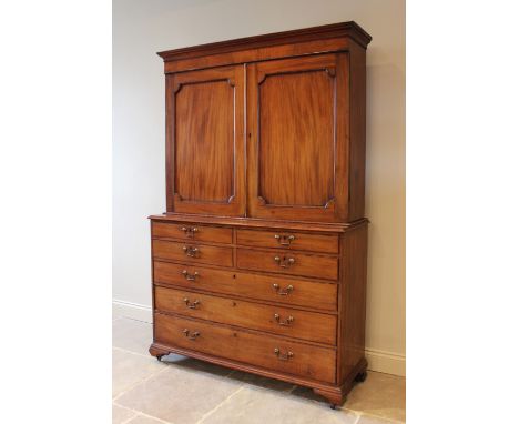 A mid 19th century mahogany linen press, the moulded cornice above a pair of invert moulded cupboard doors opening to three a
