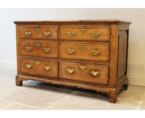 A George III oak and mahogany cross banded dresser base, the rectangular moulded top above three pairs of graduated drawers, 