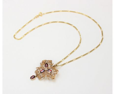 A garnet and seed pearl set Edwardian style pendant/brooch, designed as three central garnets with a surround of seed pearls 