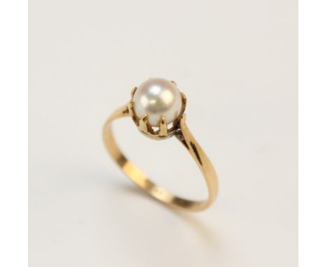 A cultured pearl set ring, the pearl measuring approx. 7mm diameter, claw set in yellow metal to tapering shoulders and plain