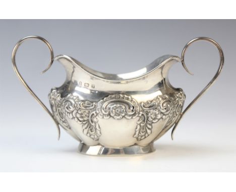 An Edwardian twin-handled silver sugar bowl by Joseph Gloster, Birmingham 1901, of oval form with shaped rim and embossed flo