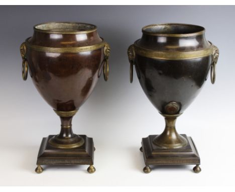 A pair of 19th century Adam style bronzed urns, of typical tapering form, with applied gilt metal rams mask ring handles upon