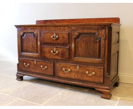 A George III oak and mahogany crossbanded dresser base, later converted from a Lancashire mule chest, the rectangular top abo