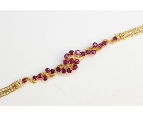 A ruby set bracelet, comprising twenty three untested oval rubies, within a 'twist' design, all set in yellow metal to a wove
